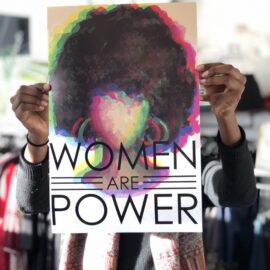"Women are Power" sign held up at Sisterhood Boutique