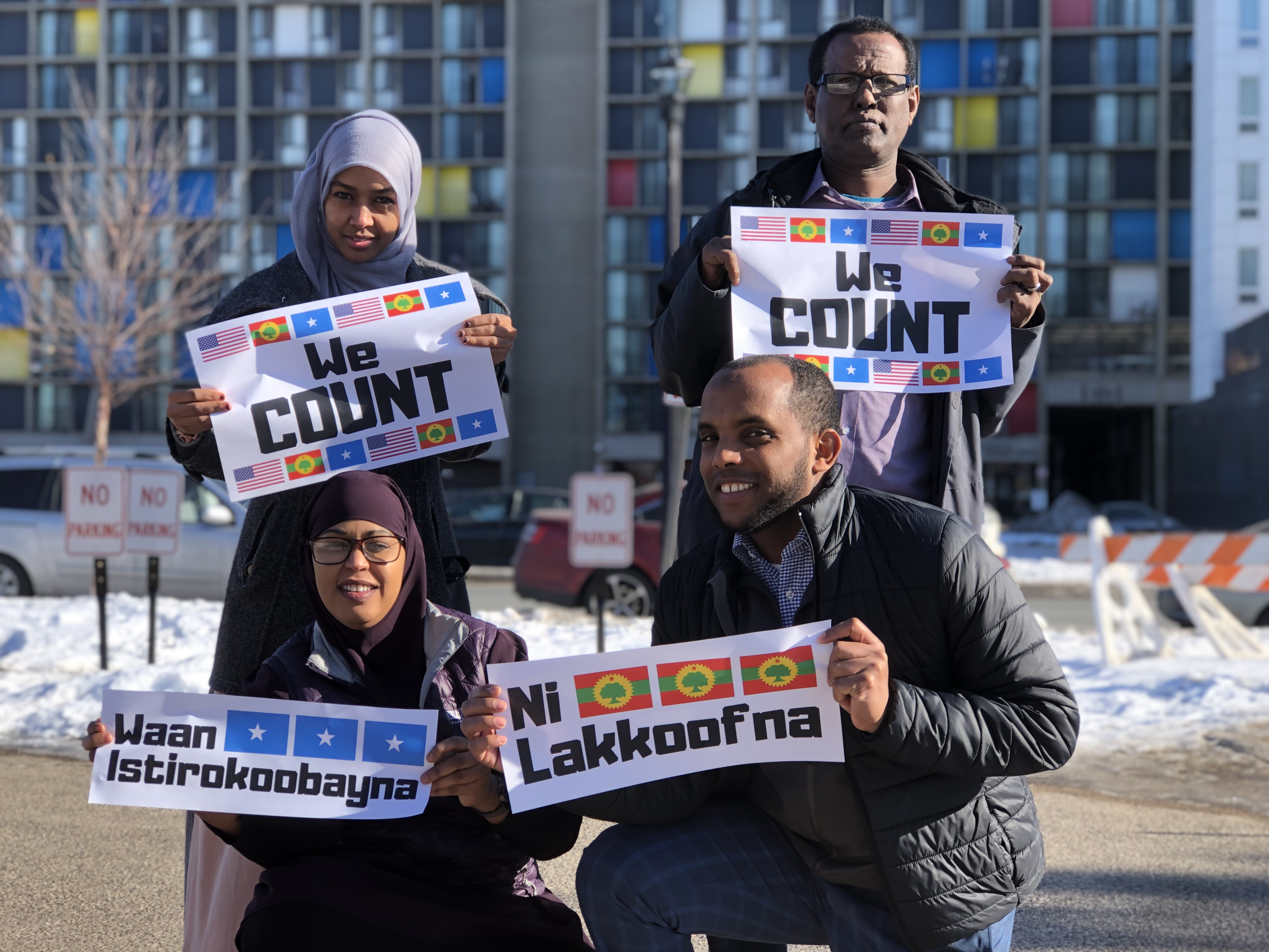 Cedar Riverside Leaders holding 'We Count' signs in English, Somali, and Oromo