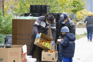 Food shelf worker distributing produce to community members