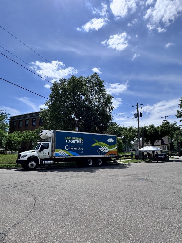 A large box truck is parked on the street in front of Oak Park Center. Behind it, someone is setting up a canopy tent.